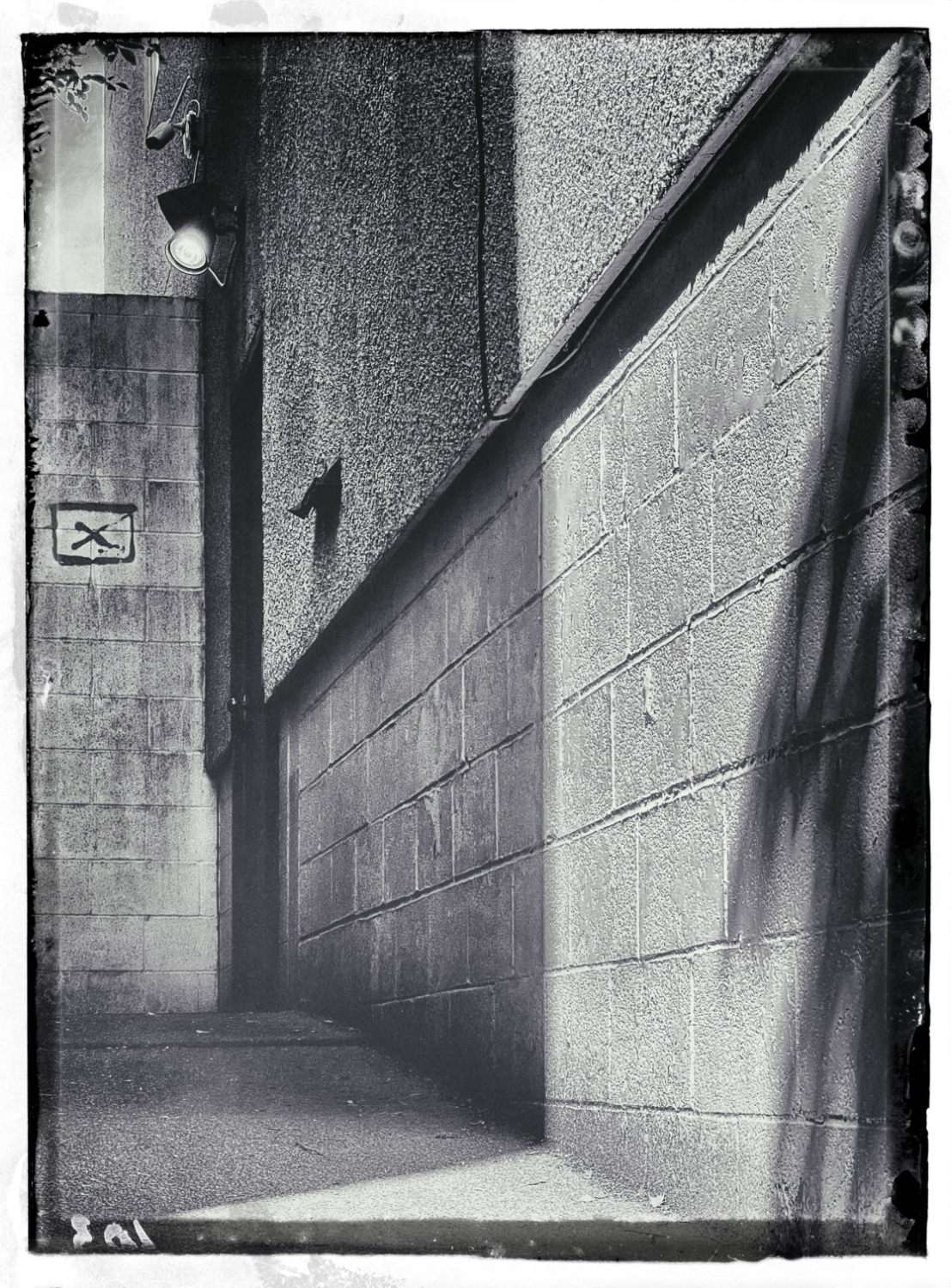 An alley with an X on the wall.